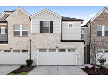 Modern two-story townhome with gray and brick exterior, two-car garage, and landscaping at 1347 Sunny Lake Dr, Lawrenceville, GA 30043