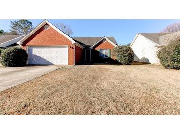 Brick ranch home with attached garage and grassy yard at 1624 Graystone Dr, Hampton, GA 30228