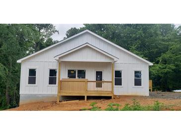 Charming new construction home with white siding, covered front porch, and beautifully wooded surroundings at 41 Walnut Trl, Cartersville, GA 30121