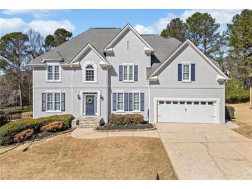 Stately two-story home featuring blue shutters, a manicured front yard, and a two-car garage at 1506 Brookridge Dr, Woodstock, GA 30189