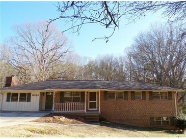 Brick ranch house with green shutters, and a spacious front yard at 10155 Twin Oaks Sw Dr, Covington, GA 30014
