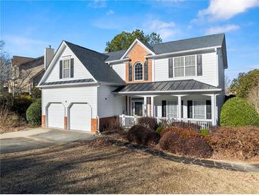 Charming two-story home featuring a two-car garage, inviting front porch, and beautifully landscaped front yard at 2352 Kelman Pl, Dacula, GA 30019