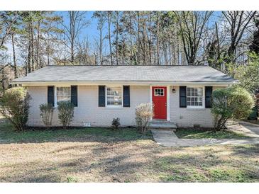 Brick ranch house with red front door, landscaping, and a spacious yard at 3212 Ward Sw Dr, Atlanta, GA 30354