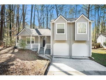 Gray two-story house with a two-car garage and a well-manicured lawn at 5063 S Woodbridge Trl, Stone Mountain, GA 30088