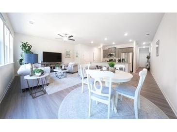 Open-concept living room with lots of seating and a modern kitchen in the background at 257 Whitetail Cir, Canton, GA 30115