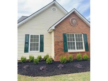 Charming exterior features a mix of brick and siding, complemented by green shutters and tasteful landscaping at 4541 Old Highway 138 Sw, Loganville, GA 30052