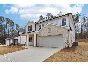 Charming two-story home featuring a two-car garage, white brick and siding, and a covered porch at 291 Martin Spring Rd, Lawrenceville, GA 30045