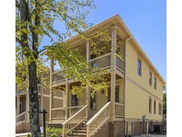 Charming two-story home featuring a double balcony, yellow siding, and inviting brick stairs at 110 Hogue St, Atlanta, GA 30312
