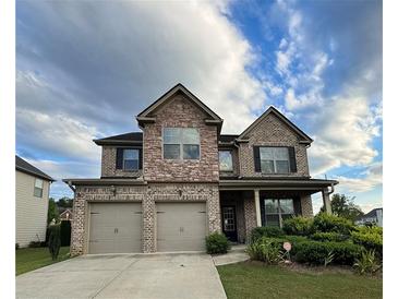 Two-story brick home with three-car garage and landscaped yard at 2239 Noelle Pl, Powder Springs, GA 30127