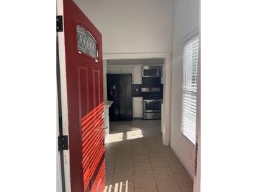 Bright entryway with red door opens to a view of the kitchen with stainless steel appliances at 2254 Wellington Cir, Lithonia, GA 30058