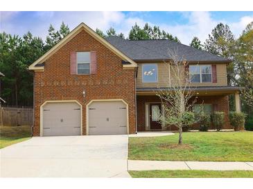Charming two-story home features a brick facade, two-car garage, and a well-manicured lawn at 7940 White Oak Loop, Lithonia, GA 30038