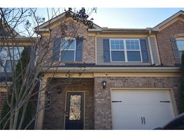 Brick front elevation of a two-story townhome with a two-car garage at 7765 Haynes Park Cir, Lithonia, GA 30038