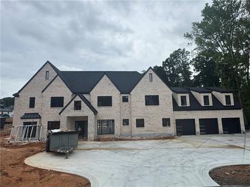 Elegant, newly built home showcases a light brick exterior, black trim and a three-car garage at 839 Braselton Hwy, Lawrenceville, GA 30043