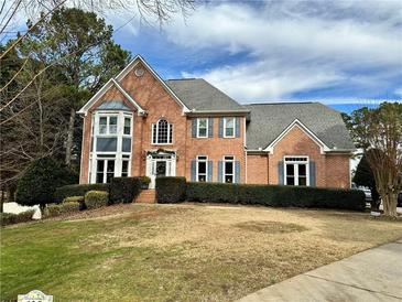 Brick house with gray roof, landscaping, and a well-manicured lawn at 125 Hillcrest Trce, Fayetteville, GA 30215