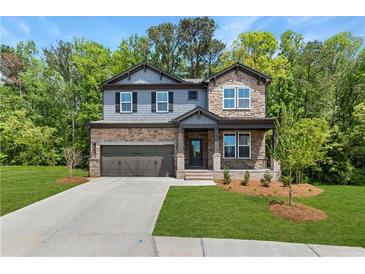 Charming two-story home featuring stone and siding exterior, manicured lawn and attached two-car garage at 4002 Adler Cir, Buford, GA 30519
