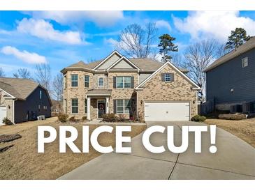 Beautiful brick home featuring manicured lawn, two-car garage and classic architectural details at 3330 Deaton Trl, Buford, GA 30519