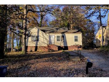 Ranch style home with a tree-lined yard and driveway at 1743 Marcel Sw Ave, Atlanta, GA 30311