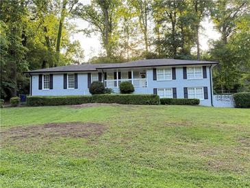 Charming single-story home features a light brick facade, black shutters, and a neatly landscaped front yard at 2418 Brookdale Ne Dr, Atlanta, GA 30345