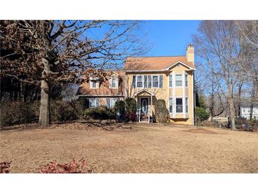 Charming yellow two-story home with a well-manicured lawn and inviting entrance at 75 Maygold St, Mcdonough, GA 30253