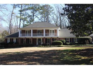 Brick home with balcony, white columns, and a landscaped lawn at 5651 Bahia Mar Cir, Stone Mountain, GA 30087