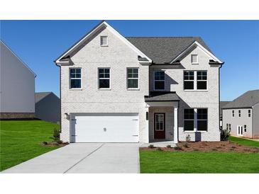Charming two-story home features a white brick facade, attached garage, and well-manicured front lawn at 313 Chattahoochee Cir, Locust Grove, GA 30248
