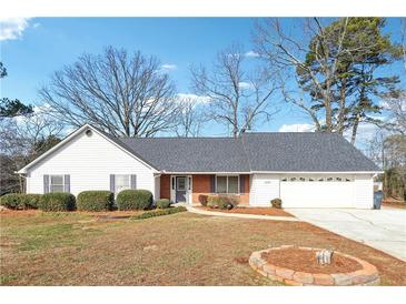 Ranch style home with attached garage and landscaped yard at 1431 Willow Bend Dr, Snellville, GA 30078