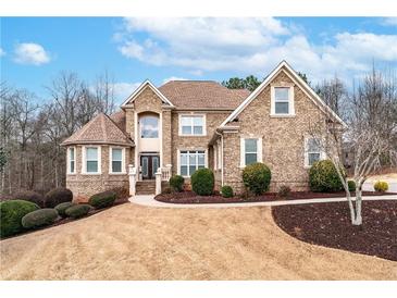 Stunning brick home featuring manicured landscaping, a circular driveway, and a welcoming entrance at 3413 Talking Creek Ct, Conyers, GA 30094