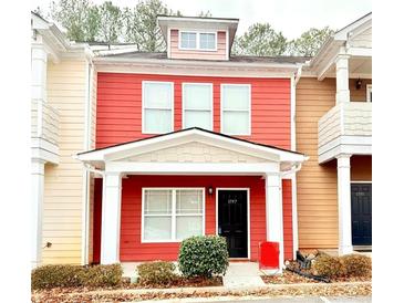 Two-story red townhome with white columns, black door, and landscaping at 1797 Brookside Lay Cir, Norcross, GA 30093