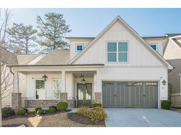 Charming two-story home with landscaped yard, gray garage door, and covered front porch at 104 Ivey Way, Woodstock, GA 30188