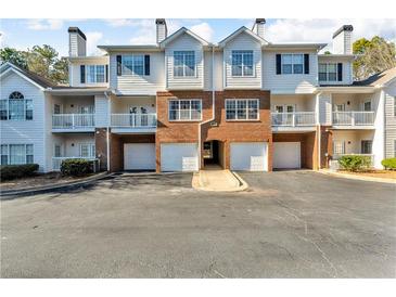 Brick front of townhome with attached garage and balconies at 308 Spring Heights Ln # 308, Smyrna, GA 30080