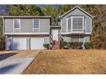 Gray two-story house with attached two-car garage and brown wooden steps at 5910 Rock Rd, Union City, GA 30291