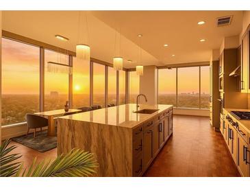Modern kitchen features a marble island, stainless steel appliances, and a stunning city view at sunset at 3630 Peachtree Ne Rd # 2207, Atlanta, GA 30326