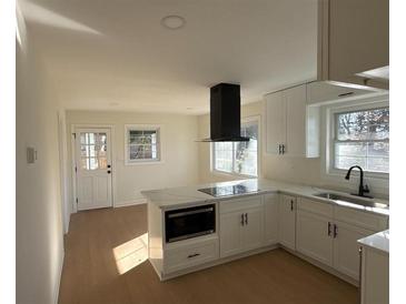 Modern kitchen featuring white cabinets, quartz countertops, and stainless steel appliances at 2662 Sweetwater St, Austell, GA 30106