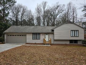 Charming single-story home featuring a neutral color scheme, attached garage and a well-manicured front yard with mature trees at 5286 Westhill Dr, Norcross, GA 30071