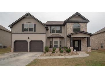 Brick and siding two-story house with a two car garage at 8103 White Oak Loop, Lithonia, GA 30038