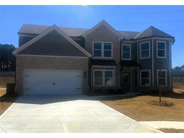 Charming two-story home with brick and siding, attached garage, and a well-manicured lawn at 446 Rodeo Dr, Auburn, GA 30011