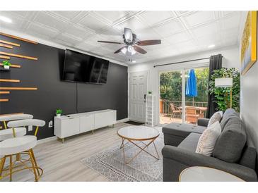 Cozy living room features a gray sofa, stylish barstools, and a sliding glass door to the outdoor deck at 1225 Church St # O, Decatur, GA 30030