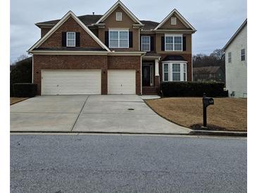 Two story brick house with three car garage and manicured lawn at 7413 Melhana Ln, Union City, GA 30291