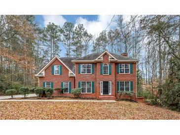 Brick two-story house with green shutters, landscaping, and a large front yard at 730 Pinehurst Dr, Fairburn, GA 30213