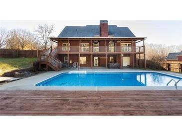Stunning backyard with large in-ground pool, deck, and two story brick home with balconies at 116 Big Cotton Trl, Mcdonough, GA 30252