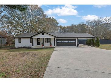 White house with black accents, two-car garage, and landscaped yard at 97 Grayson New Hope Rd, Grayson, GA 30017