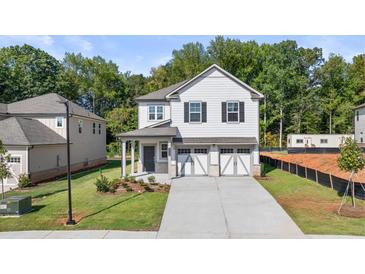 Two-story house with white siding, gray accents, and a two-car garage at 2448 Lenox Se Rd, Conyers, GA 30094