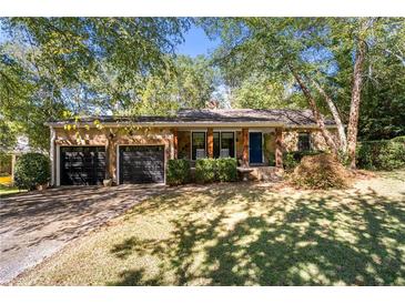 Stone house with a two-car garage and a large front yard at 1452 Merriman Ne Ln, Atlanta, GA 30324