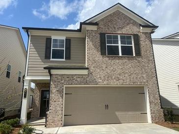 Two-story home featuring brick and siding, complemented by a two-car garage at 4311 Portsbrook Ave, Snellville, GA 30039
