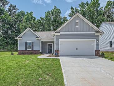 Charming single-story home with a two-car garage, gray siding, and a well-maintained lawn at 213 Cottontail Ln, Villa Rica, GA 30180