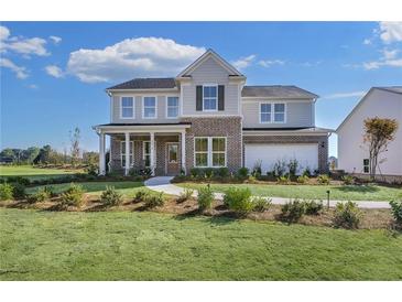 Two-story house with brick and siding, landscaped yard, and a curved driveway at 3136 Morris Hills Dr, Dacula, GA 30019