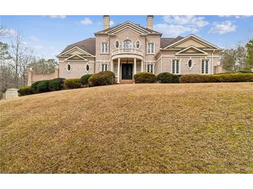 Brick Georgian style home with manicured lawn on a sloping lot at 5473 Olde Plantation Dr, Douglasville, GA 30135