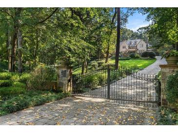 Estate home featuring an inviting gated entry, long driveway, and lush, mature landscaping at 4345 Mount Paran Nw Pkwy, Atlanta, GA 30327