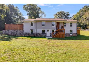 Two-story home with gray siding, large yard, and deck at 7077 Milam Rd, Winston, GA 30187