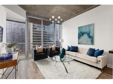 Bright living room with a fluffy rug and a neutral color palette offers city views through large windows at 855 Peachtree Ne St # 1508, Atlanta, GA 30308